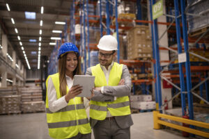Managers controlling distribution and checking inventory in warehouse storage.